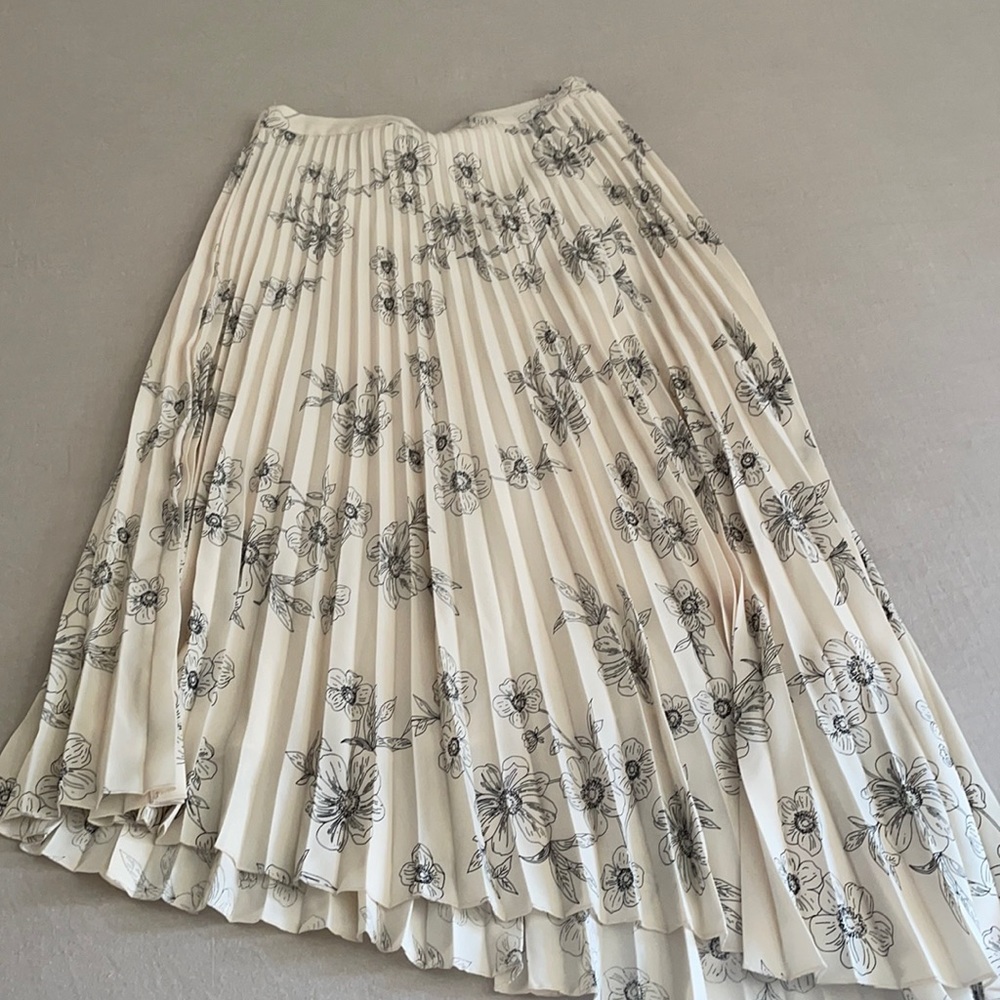 Pleated asymmetrical skirt with floral design.